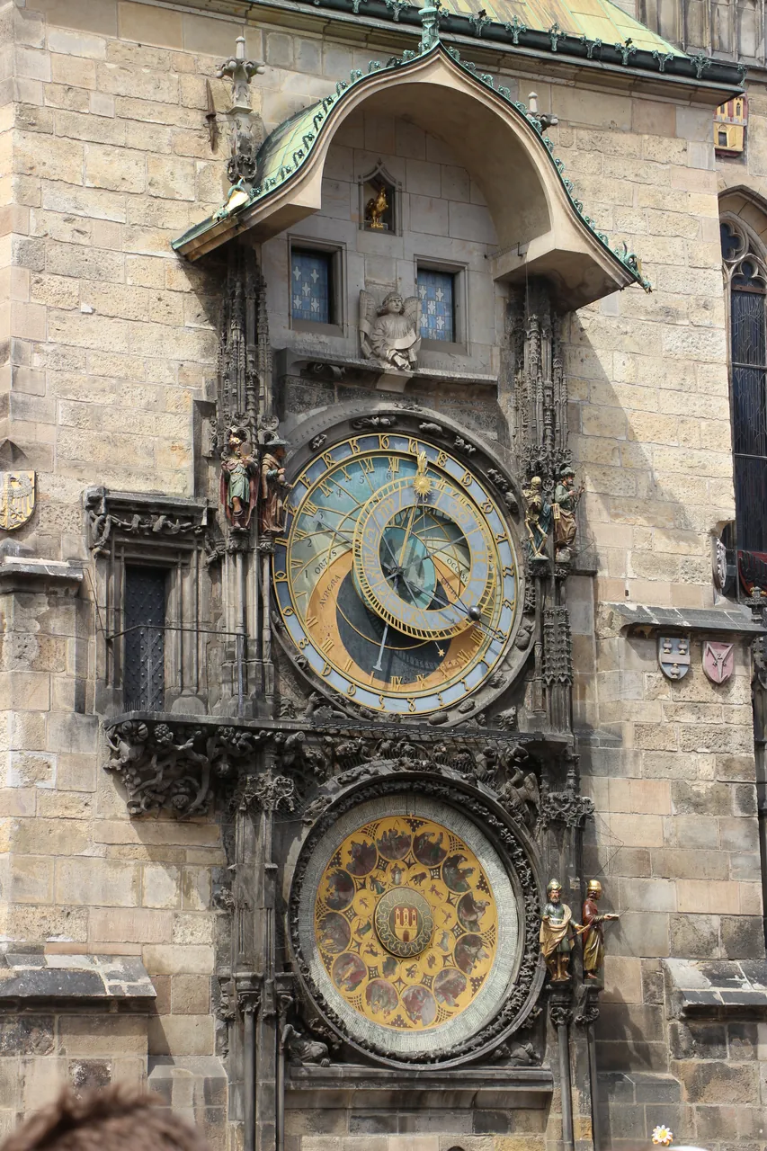 A detailed, straight-on view of the Prague Astronomical Clock mounted on a historic stone wall.